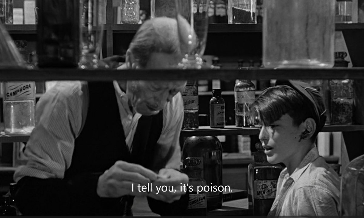 Black-and-white still: an apothecary tells a boy 'I tell you, it's poison.'